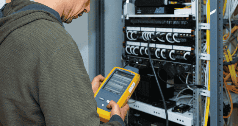 electricien à tarbes et Pau, un agent de Lo Piccolo mesure un tableau électrique d'un batiment